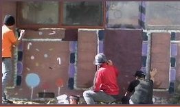 Here's an alt tag for the image: > Teenagers painting a colorful mural.