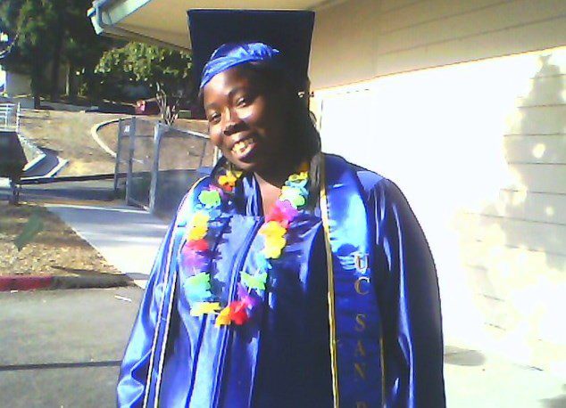 Here's an alt tag for the image: Smiling graduate in blue cap and gown.