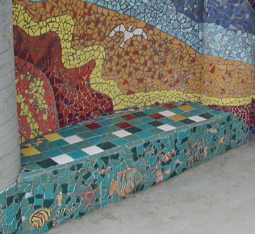 Colorful mosaic bench with ocean scene.