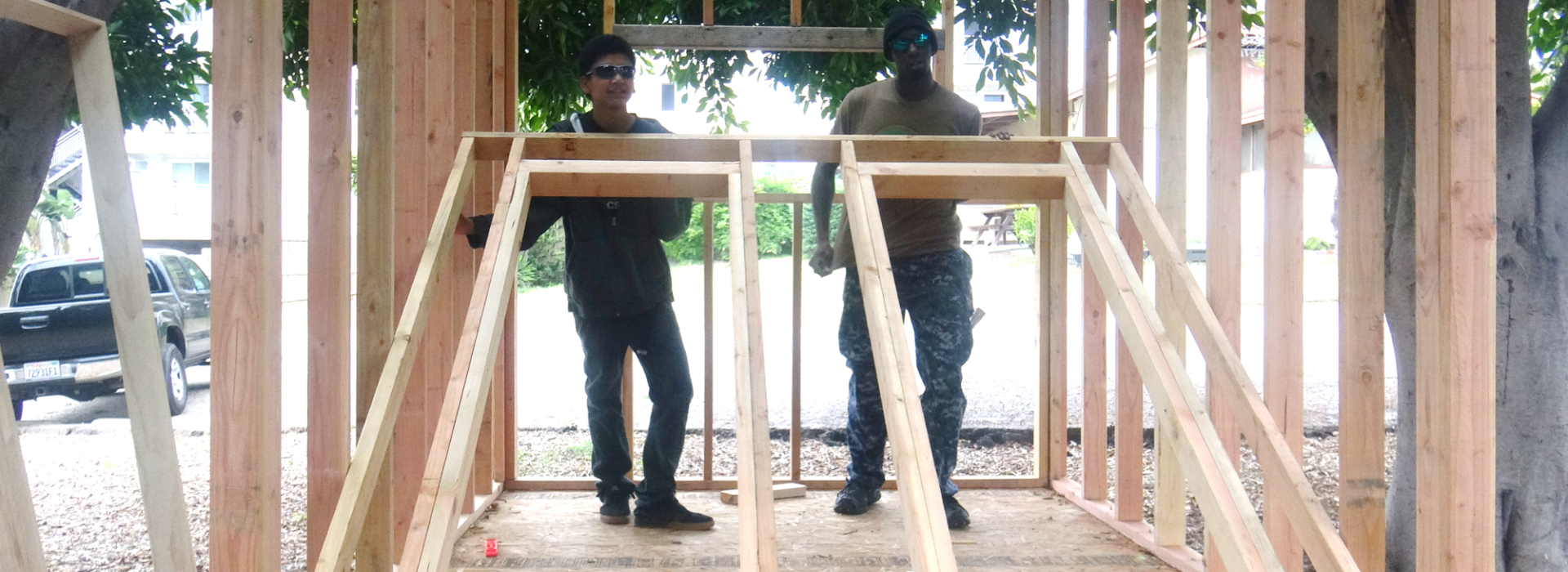 Two men building a wooden structure.