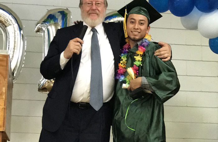 Graduate with proud mentor at ceremony.